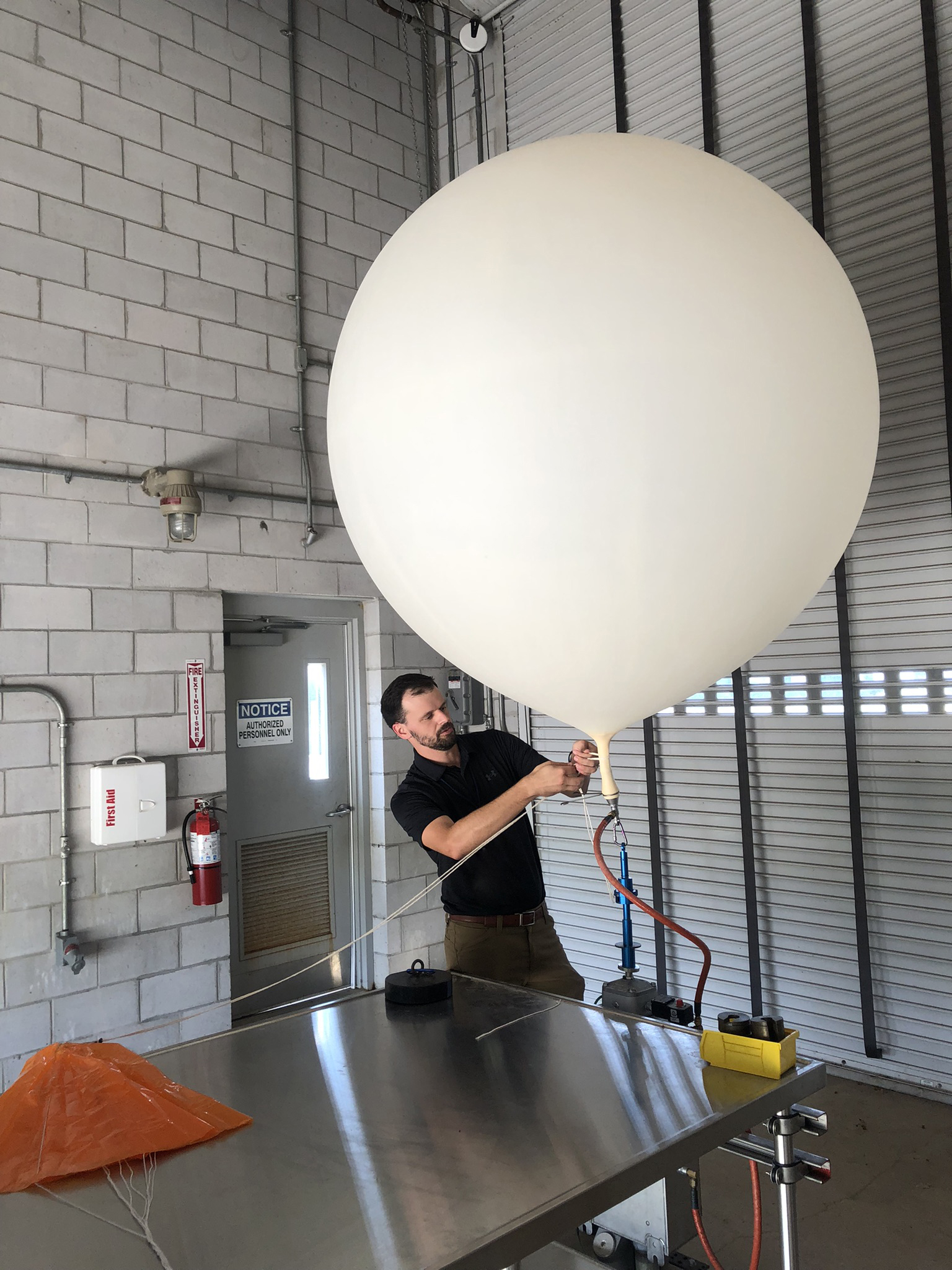 Weather balloon being tethered to a parachute and radiosonde.